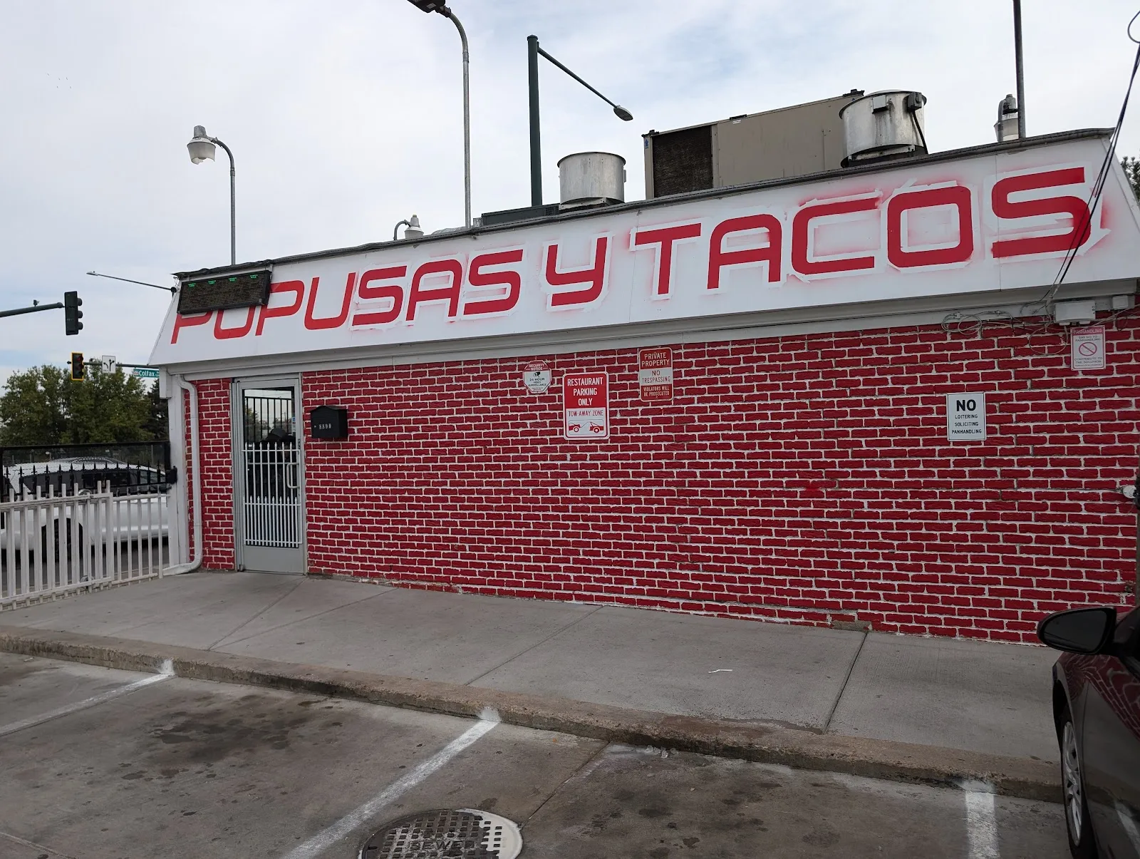 Red Pupusas y Tacos lettering across the white-and-red brick storefront